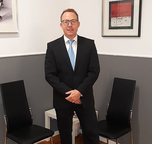 Helmar Müller posiert im Wartezimmer seiner Kanzlei